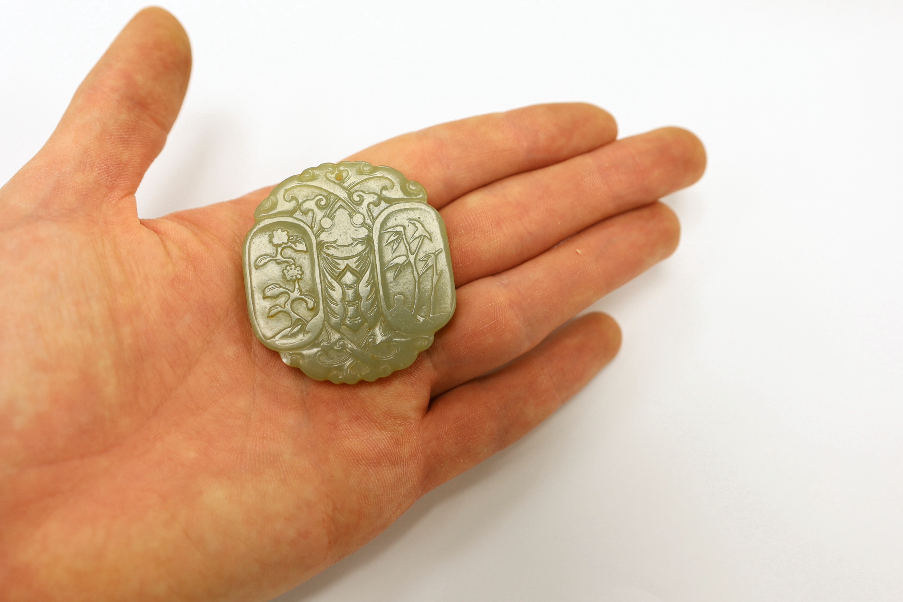 A Chinese carved jade pendant and another carving of a recumbent lion dog, largest 5cm